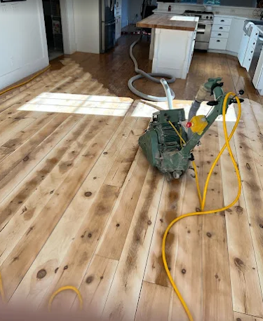 Wide-plank floor sanded back to raw wood mid-refinish